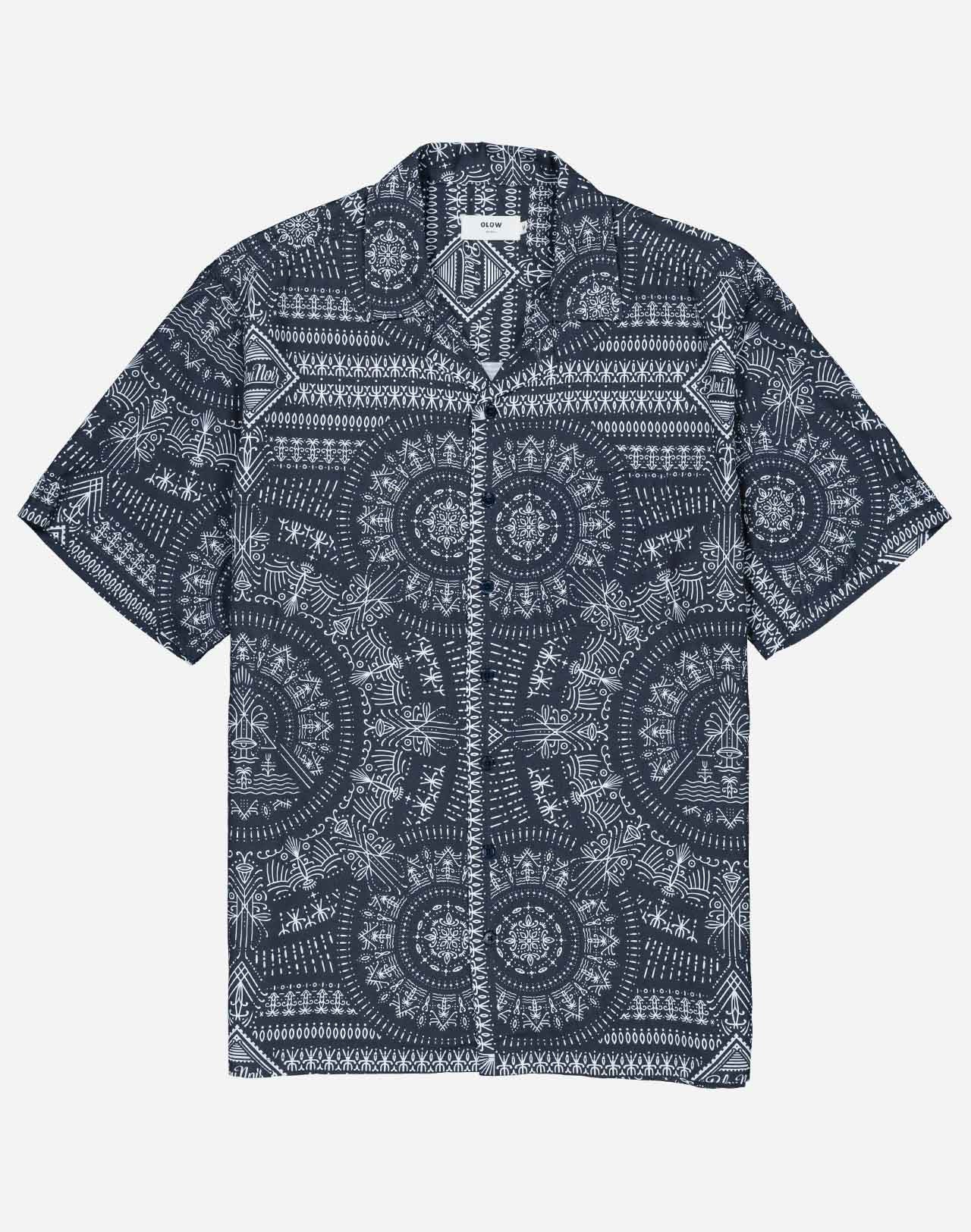 A summer silhouette, fluid and lightweight, enhanced by artist Jeykill’s graphic digital print patterns and a discreet chest pocket. Its play of midnight blue patterns adds depth while remaining easy to pair, from the matching shorts to more understated trousers.