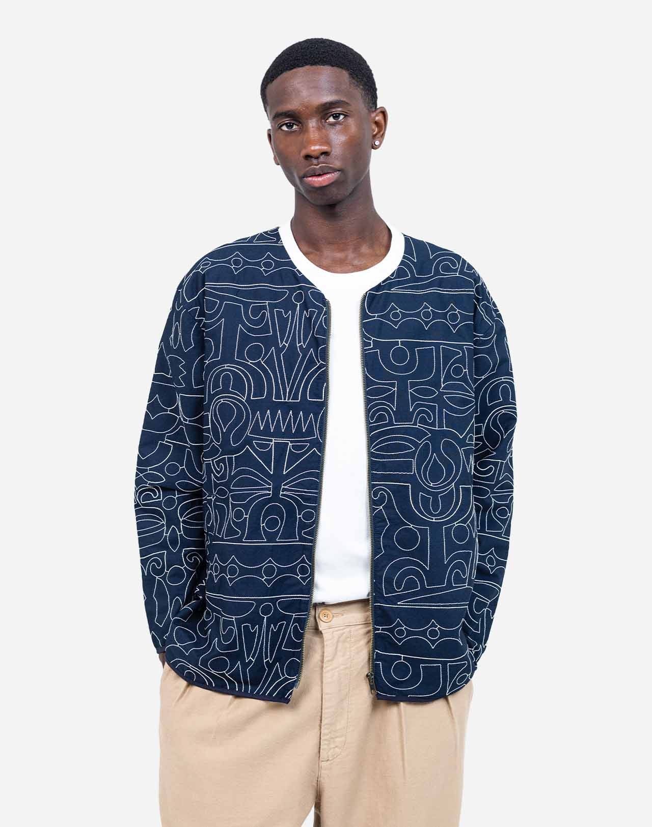 Artist Jeykill’s unique line work is embroidered in an all-over pattern on this organic cotton and recycled polyester zip-up jacket. The combination of dark navy and ecru embroidery makes this garment easy to pair with both vibrant and classic colors, whether worn with jeans or as a total look with the matching trousers. Assuredly a standout piece of the collection.