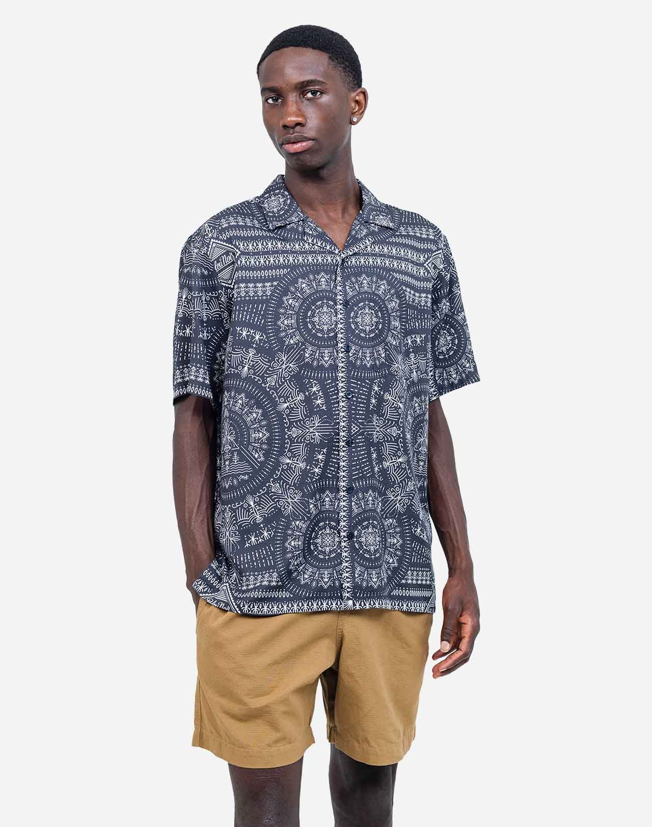 A summer silhouette, fluid and lightweight, enhanced by artist Jeykill’s graphic digital print patterns and a discreet chest pocket. Its play of midnight blue patterns adds depth while remaining easy to pair, from the matching shorts to more understated trousers.