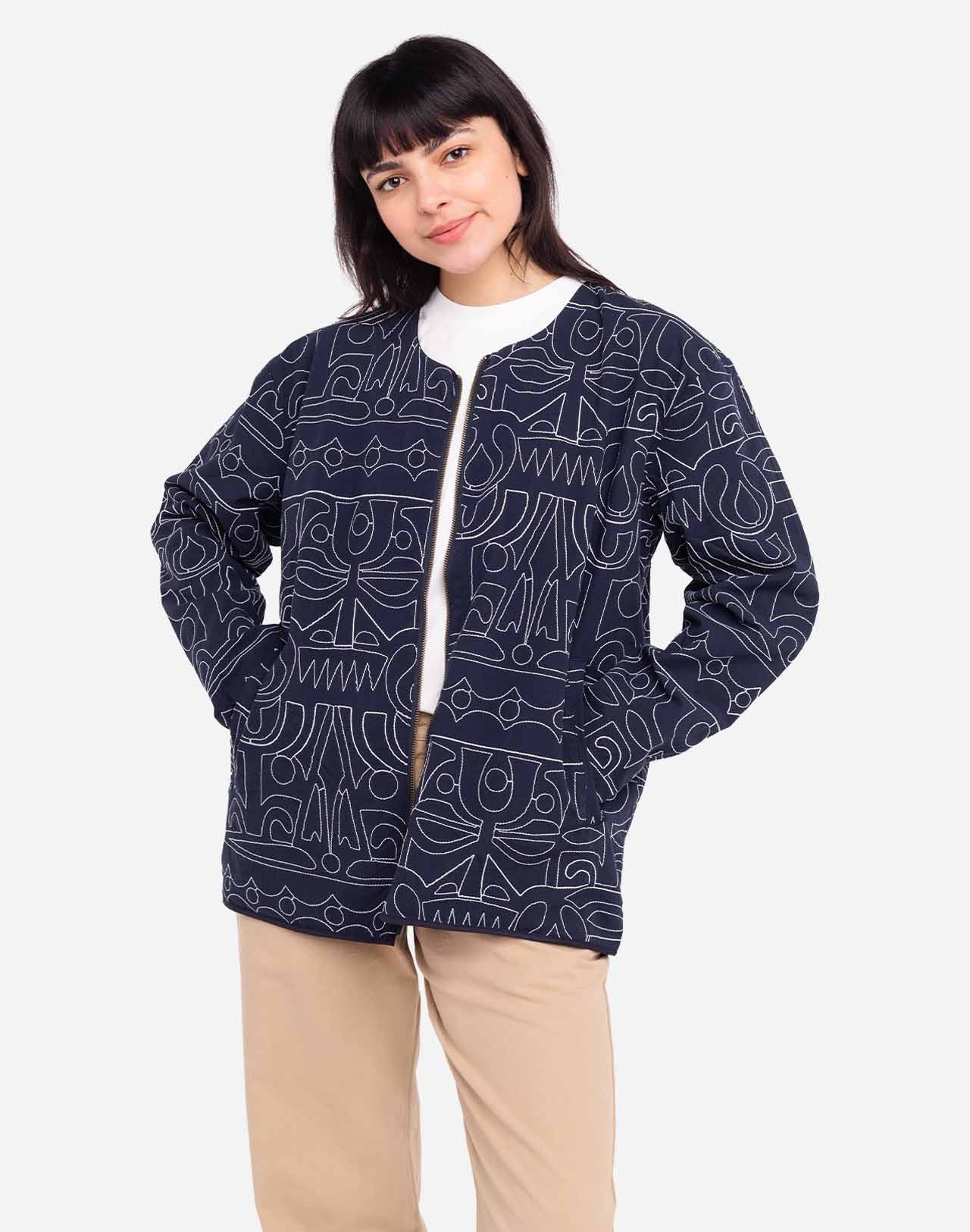Artist Jeykill’s unique line work is embroidered in an all-over pattern on this organic cotton and recycled polyester zip-up jacket. The combination of dark navy and ecru embroidery makes this garment easy to pair with both vibrant and classic colors, whether worn with jeans or as a total look with the matching trousers. Assuredly a standout piece of the collection.