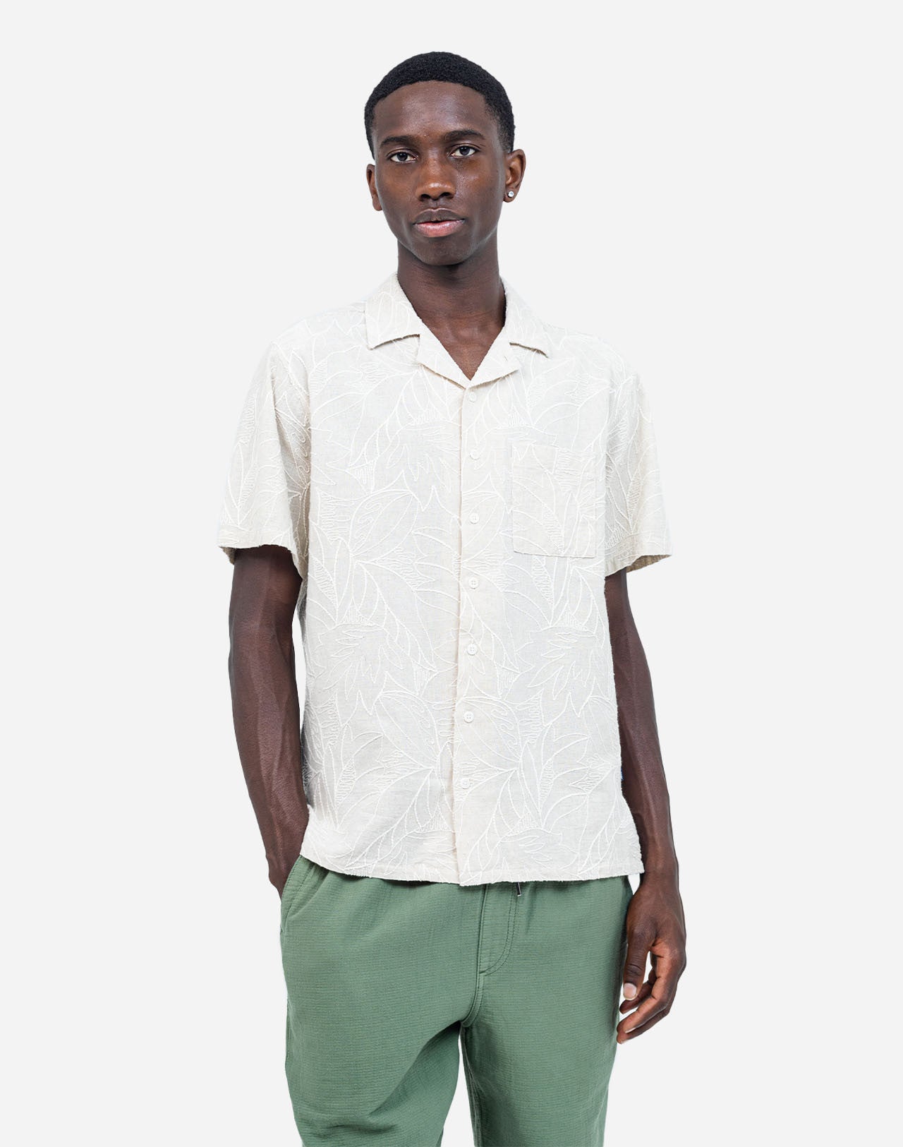 Fine all-over embroideries trace a subtle botanical pattern on this Hawaiian-cut short-sleeved shirt. A summery, bright, and relaxed silhouette, carried by a soft ecru shade that is easy to integrate into any summer wardrobe. Crafted from a lightweight, textured fabric, the Aloha Welli shirt combines comfort and structure.