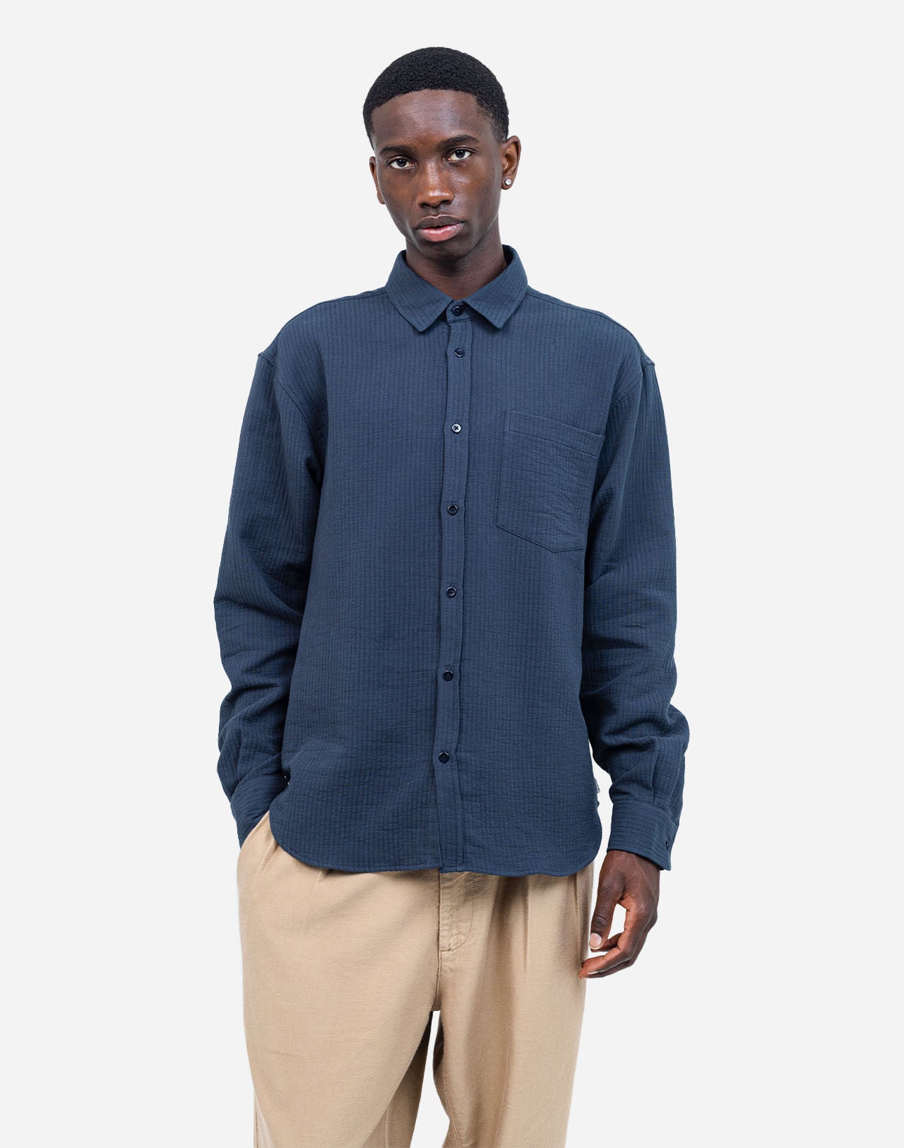 A straight-cut shirt with a curved hem, crafted from a soft and comfortable cotton gauze woven in France, textured with rows of topstitching. A timeless fit that can be worn for any occasion.