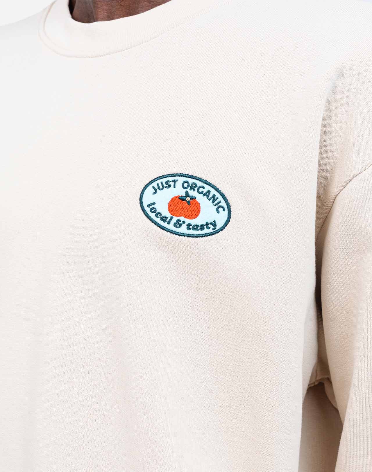 Loose-fit sweatshirt, crafted from GOTS-certified organic cotton fleece with a soft touch. Ribbed trims define the silhouette. At its heart, an embroidered patch, and on the back, felt inserts add depth to the illustration by artist Caìt McEniff.