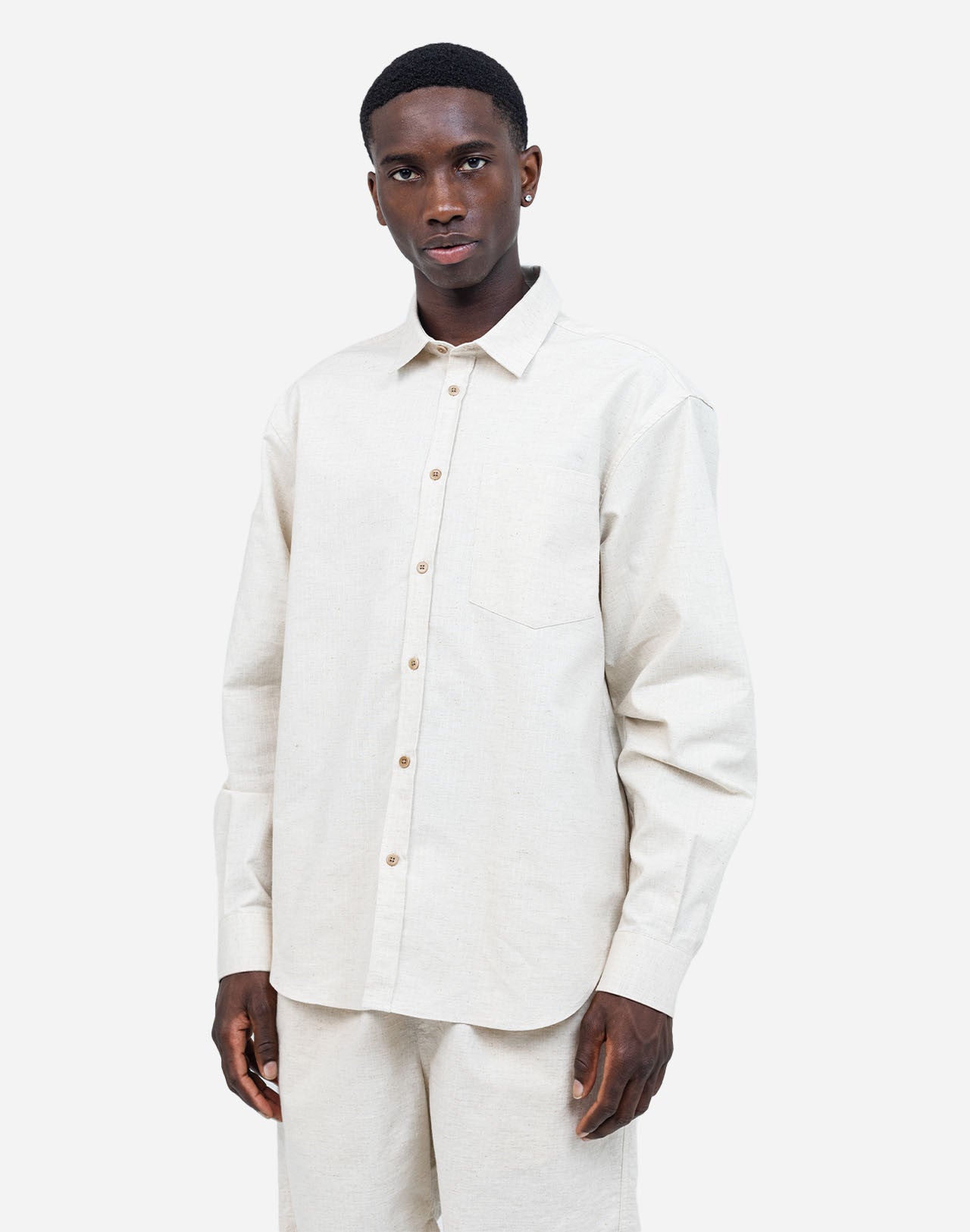 A straight-cut shirt with a curved hem, crafted from a soft and comfortable cotton gauze woven in France, textured with rows of topstitching. A timeless fit that can be worn for any occasion.